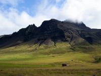 Dunkle Berge und grüne Wiesen